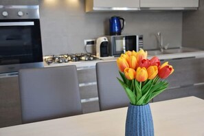 Een moderne keuken met een gasfornuis, een magnetron en een waterkoker.