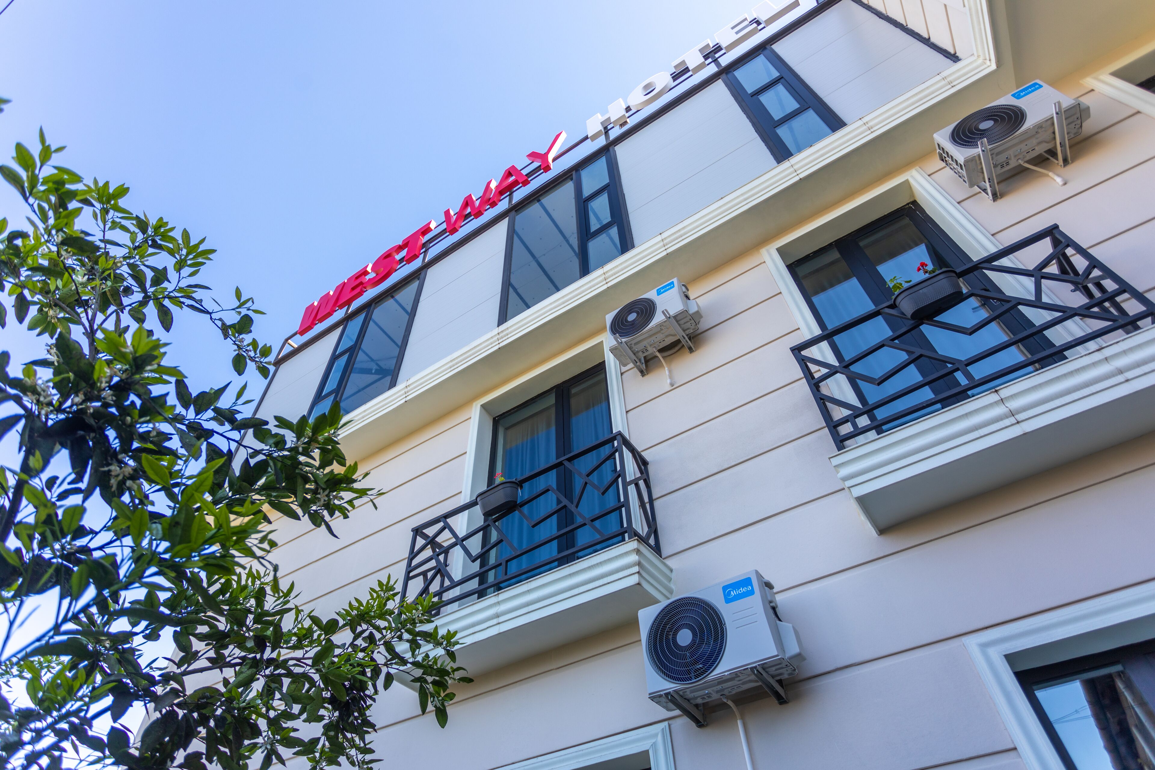 Un hôtel avec une enseigne bien visible indiquant « WEST WAY HOTEL ».