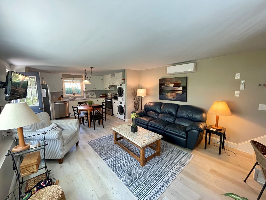 Ein Wohnzimmer mit einer Couch, einem Couchtisch und einem Essbereich mit Stühlen und einem Tisch.