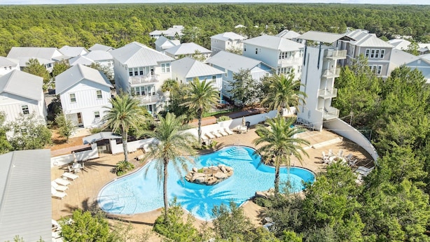 Un quartier résidentiel comprenant plusieurs maisons, une piscine et un jardin aménagé.