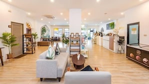 A spacious lobby with a reception desk, seating area, and a staircase leading to upper floors. - Mystays Phuket (Ko Kaeo)