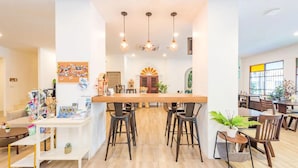 A spacious dining area with a central island, multiple chairs, and hanging pendant lights. - Mystays Phuket (Ko Kaeo)