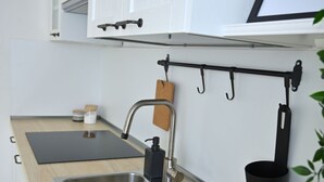 A modern kitchen with white cabinets, a stainless steel sink, and a black countertop. - Holiday home in historical center a few minutes from the sea.  (Treglio)