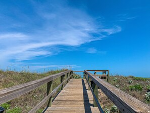 A wooden boardwalk leading to a structure with a view of the ocean. - Ocean View, Shared Pool/Hot Tub, Boardwalk to Beach (Port Aransas)