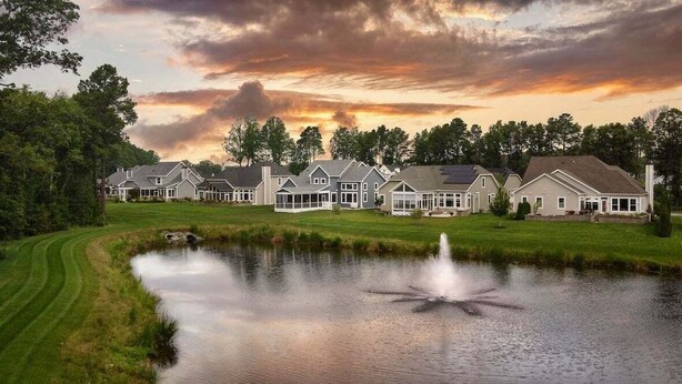 A row of houses with a pond and fountain in the foreground. - *Private Hot Tub* 4BR Luxury Beach Home *37096* (Lewes)