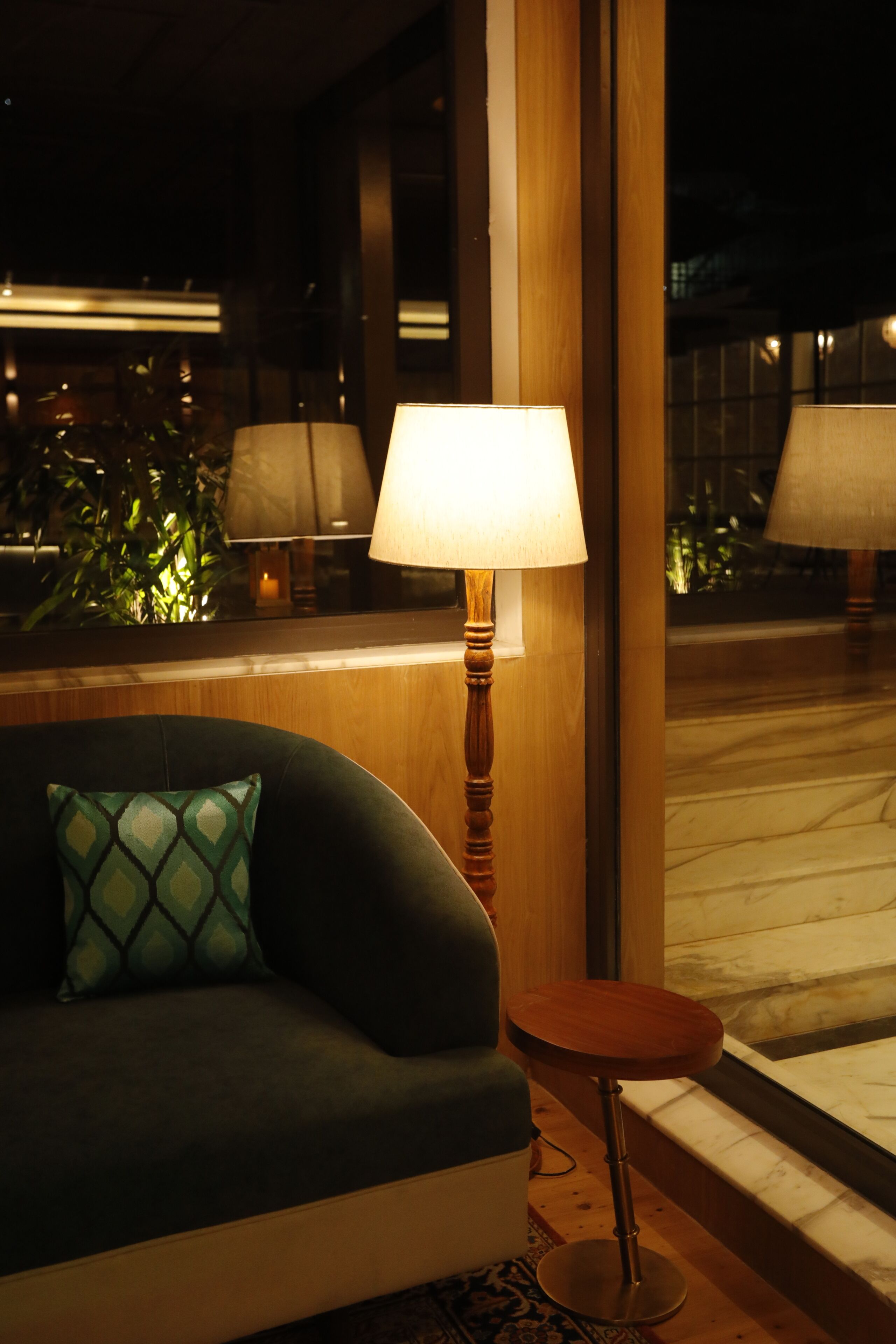 Une pièce avec un canapé, une petite table ronde et une lampe.