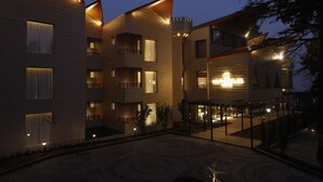 Um hotel com vários andares, varandas, um pátio interno e uma placa com a inscrição 'ARLINGTON CASTLES'.
