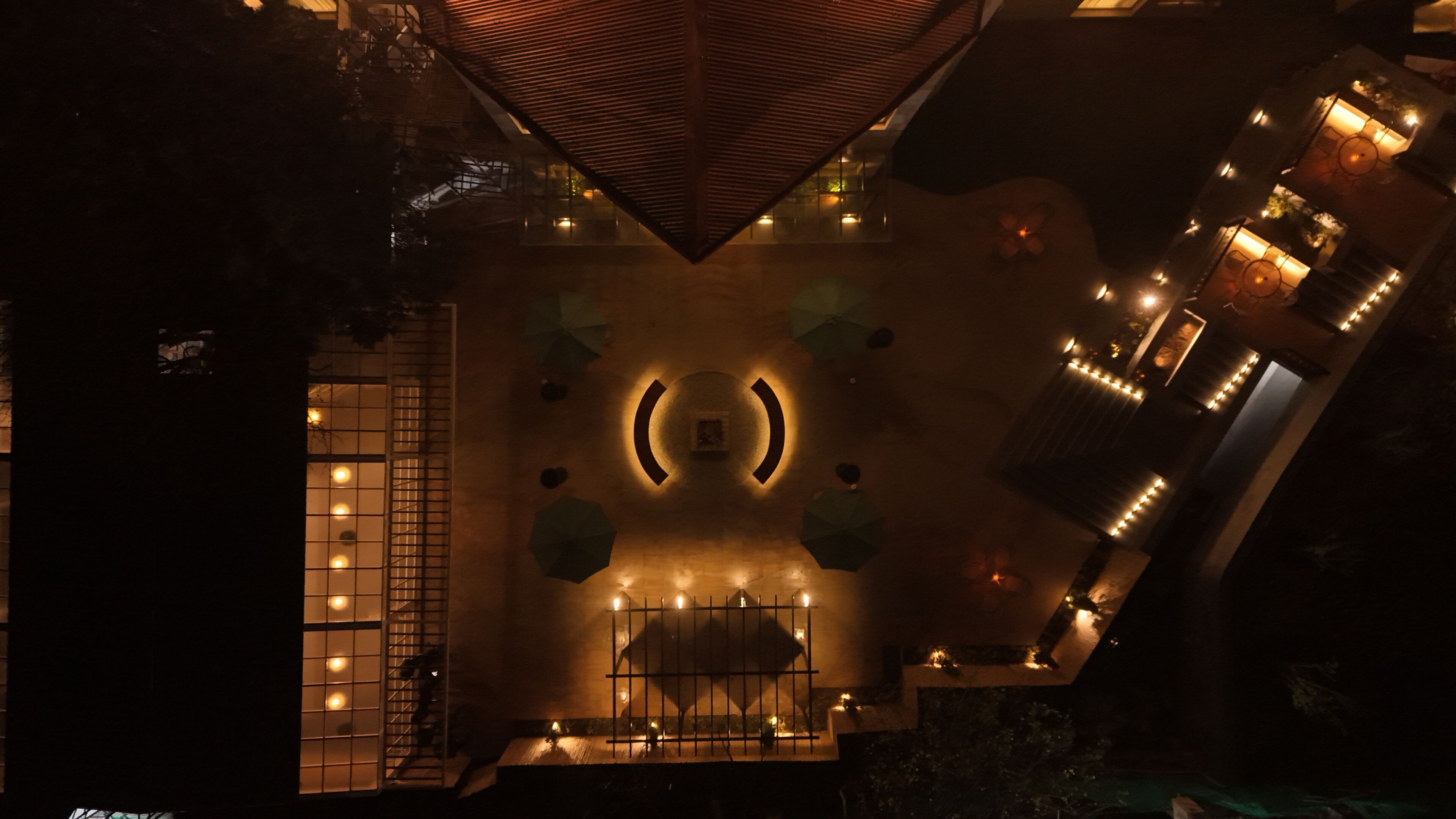 A hotel atrium with a central circular design, a staircase, and multiple illuminated areas.