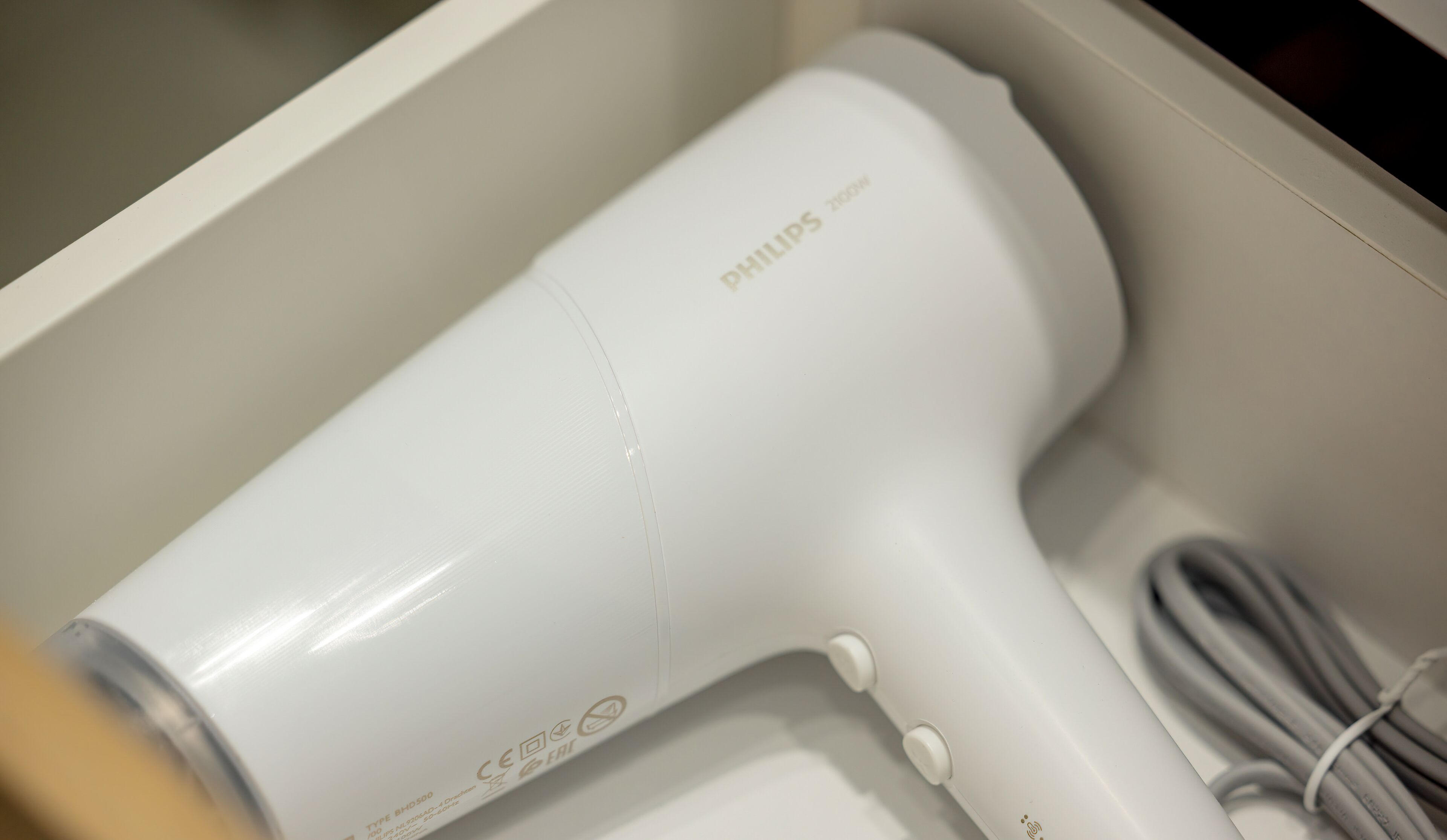 Ein weißer Philips-Haartrockner mit Kabel in einer weißen Schachtel.