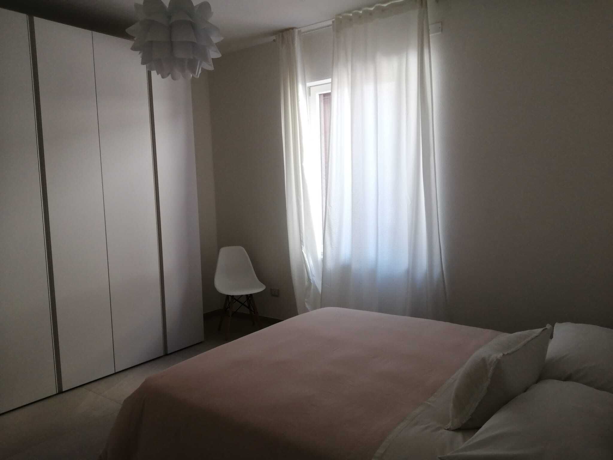 Une chambre à coucher avec un lit, une chaise et une armoire.