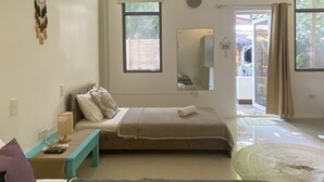 Une chambre à coucher avec un lit, une table de chevet, une lampe et un attrape-rêves accroché au mur.