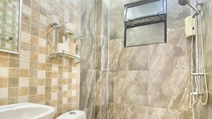 Une salle de bain avec un lavabo, des toilettes et une douche.