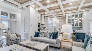 Una cocina moderna con armarios blancos, una isla central y un colgador de luces.