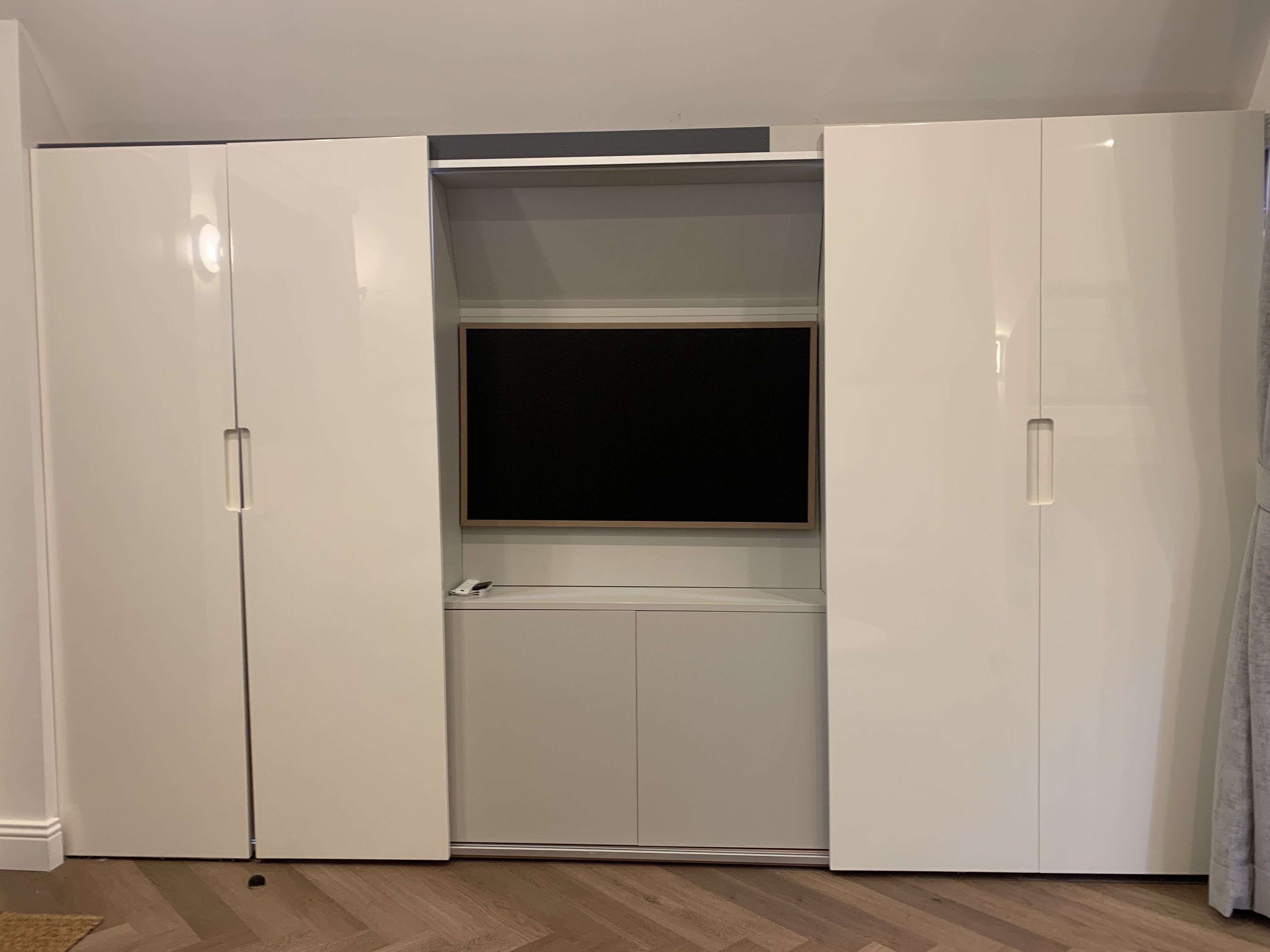 A room with a built-in wardrobe and a television.