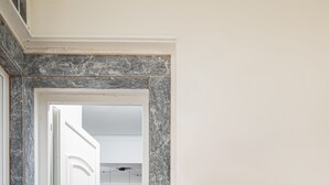 A modern entrance with a marble floor, a door leading to a dining area, and a sign reading "ICOS CITY 2".