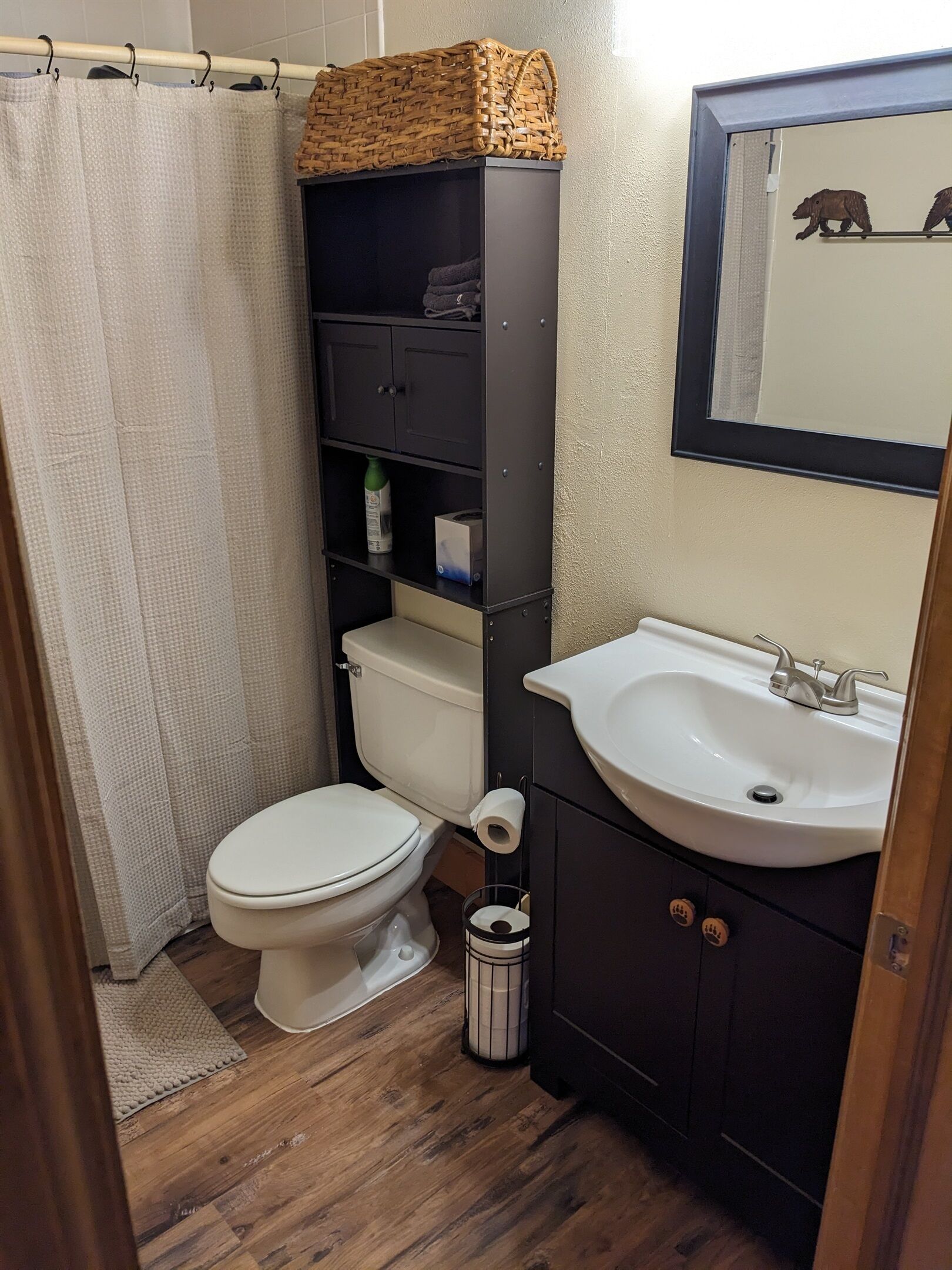 Ein kleines Badezimmer mit Toilette, einem weißen Waschbecken und einem Ablagefach mit Toilettenartikeln.