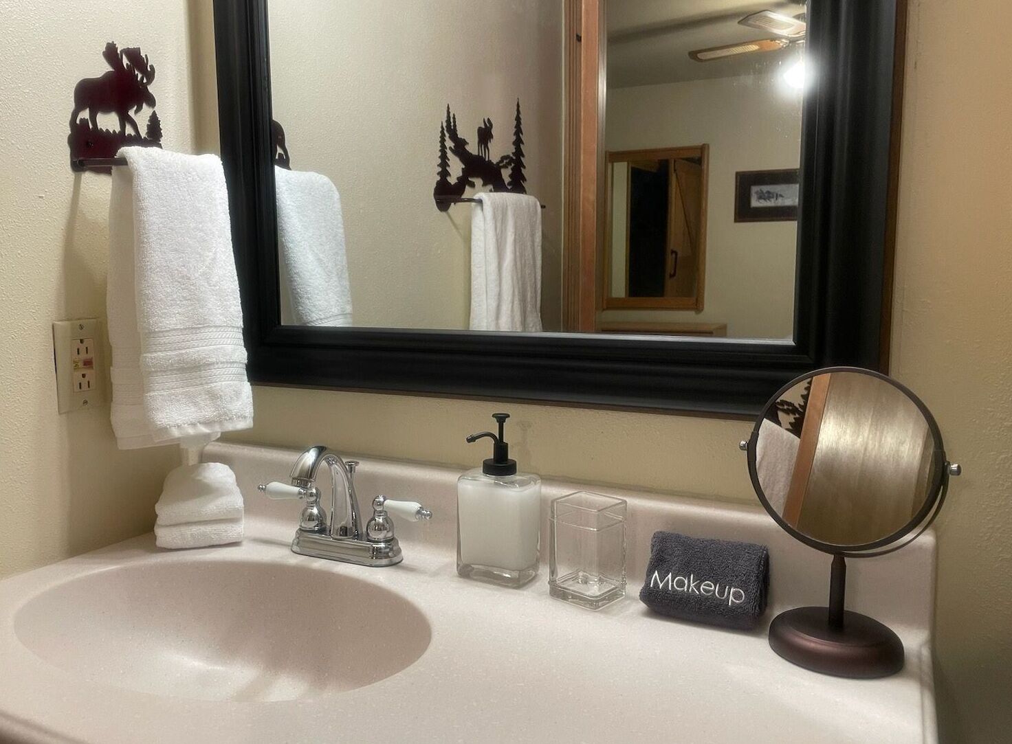 Un baño con lavabo, espejo y dos toallas.