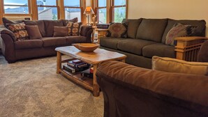 A cozy living room with two sofas, a coffee table, and a bookshelf. - Incredible MTN Views | In-Town | Pool | Hot Tub (Durango)