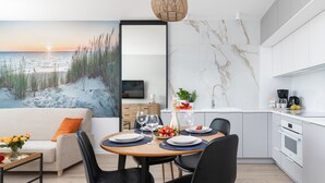 Una cocina moderna con comedor, sofá y vista al mar.