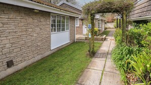 Un bâtiment en pierre doté d’un jardin et d’un sentier.