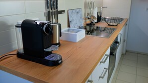 Eine Küche mit Kaffeemaschine, Spüle und diversen Kochutensilien.