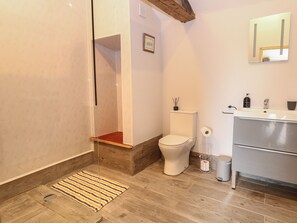 A modern bathroom with a shower, toilet, and sink. - Bee Happy Barn (Norwich)