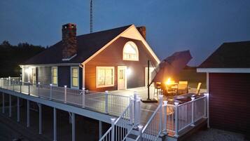 Une maison à deux étages avec un balcon, une cheminée et une antenne parabolique.
