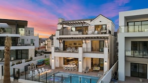 A multi-story residential building with a rooftop pool, outdoor seating, and a covered patio area. - The Beach Front 2.0: Private Pool, Lagoon + Beaches (St George)