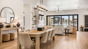 A modern kitchen with a dining area, large windows, and a ceiling fan. - The Beach Front 2.0: Private Pool, Lagoon + Beaches (St George)