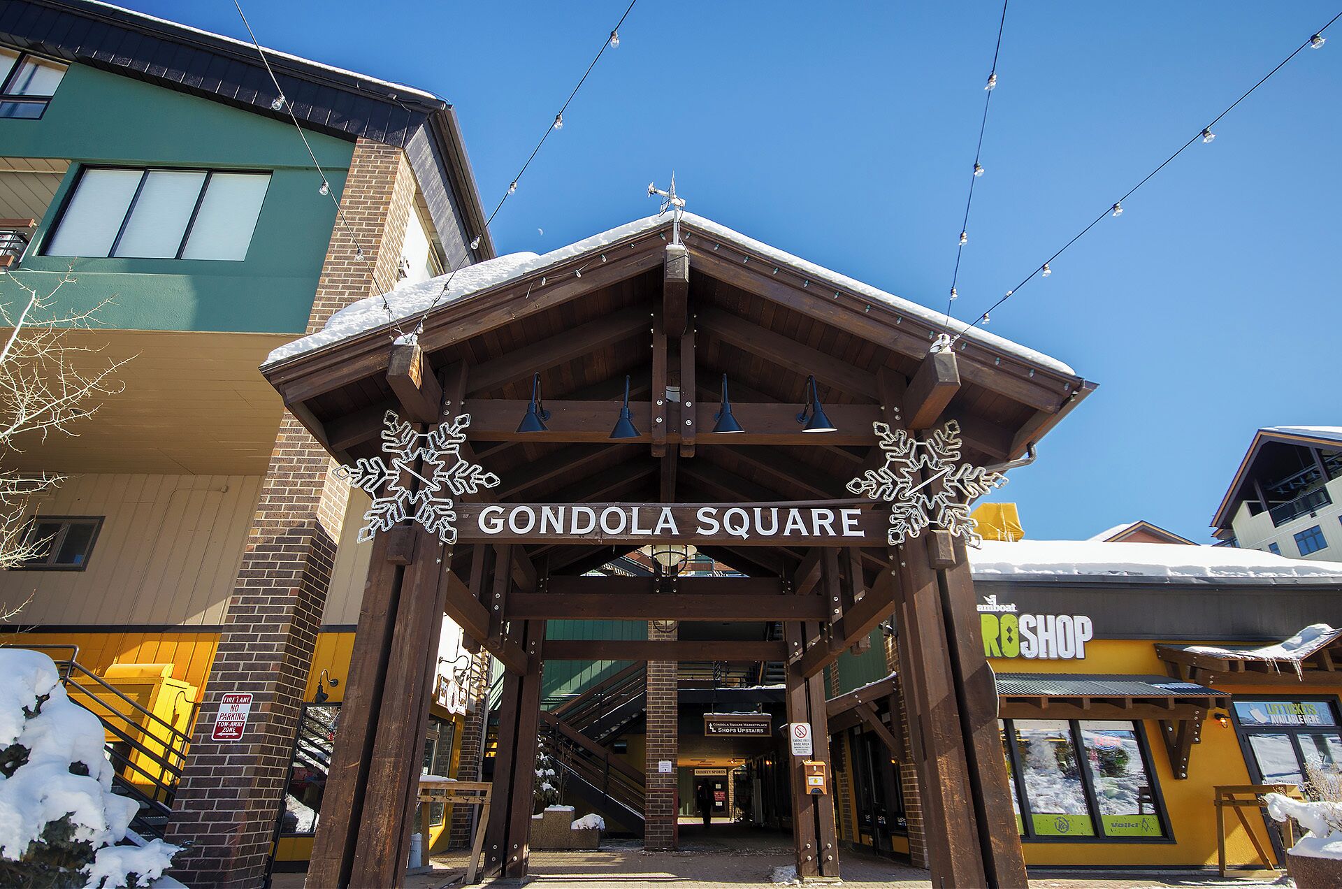 Une entrée d’immeuble avec une enseigne indiquant « Place de la Gondole » et, au fond, une boutique nommée « Ros Shop ».