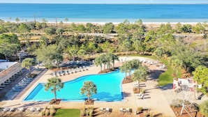 Ein Resort mit einem großen Pool, Liegestühlen und Blick auf den Ozean.