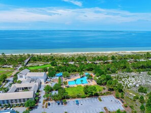 A resort with a swimming pool, parking area, and a view of the ocean. - Large Single Level, 4BR with Lots of Entertainment in WindMark ~ Paradise Found (Windmark Beach)