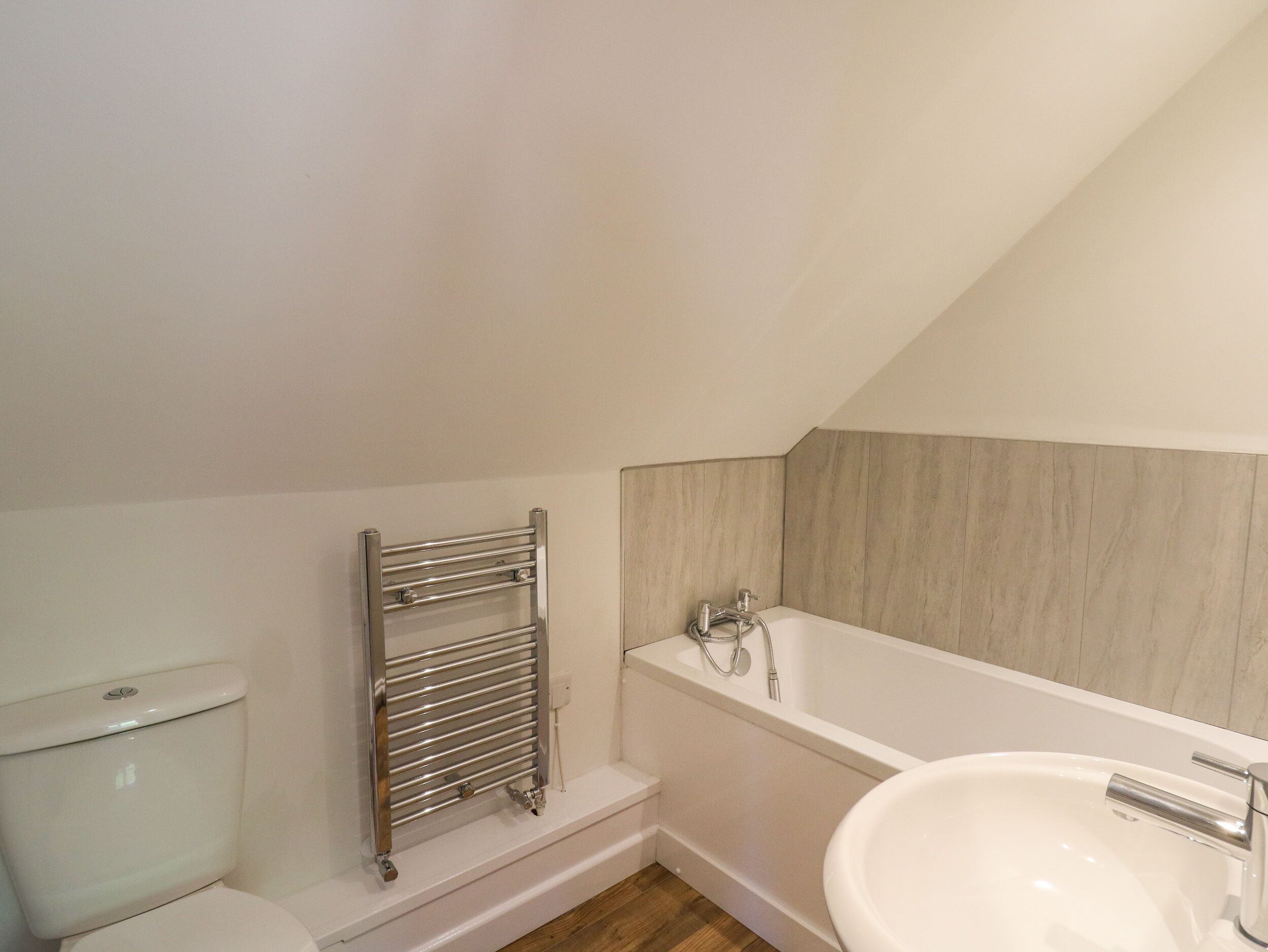 Une salle de bain comprenant des toilettes, un porte-serviettes, une baignoire et un lavabo.