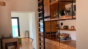 A kitchen with wooden shelves, a stool, and a countertop. - SUNSET (Cefalù)