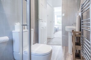 Un baño moderno con inodoro, ducha y lavabo.