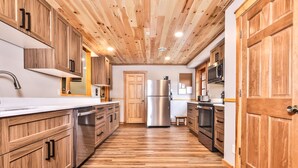 Una cocina moderna con armarios de madera, electrodomésticos de acero inoxidable y suelo de madera.