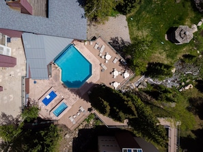 An aerial view of a residential property with a swimming pool, a separate hot tub, and a deck area with outdoor furniture. - Iron Horse C5013 Condo by RedAwning (Winter Park)