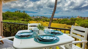 Una mesa para cuatro con vista a un paisaje exuberante y montañas distantes.