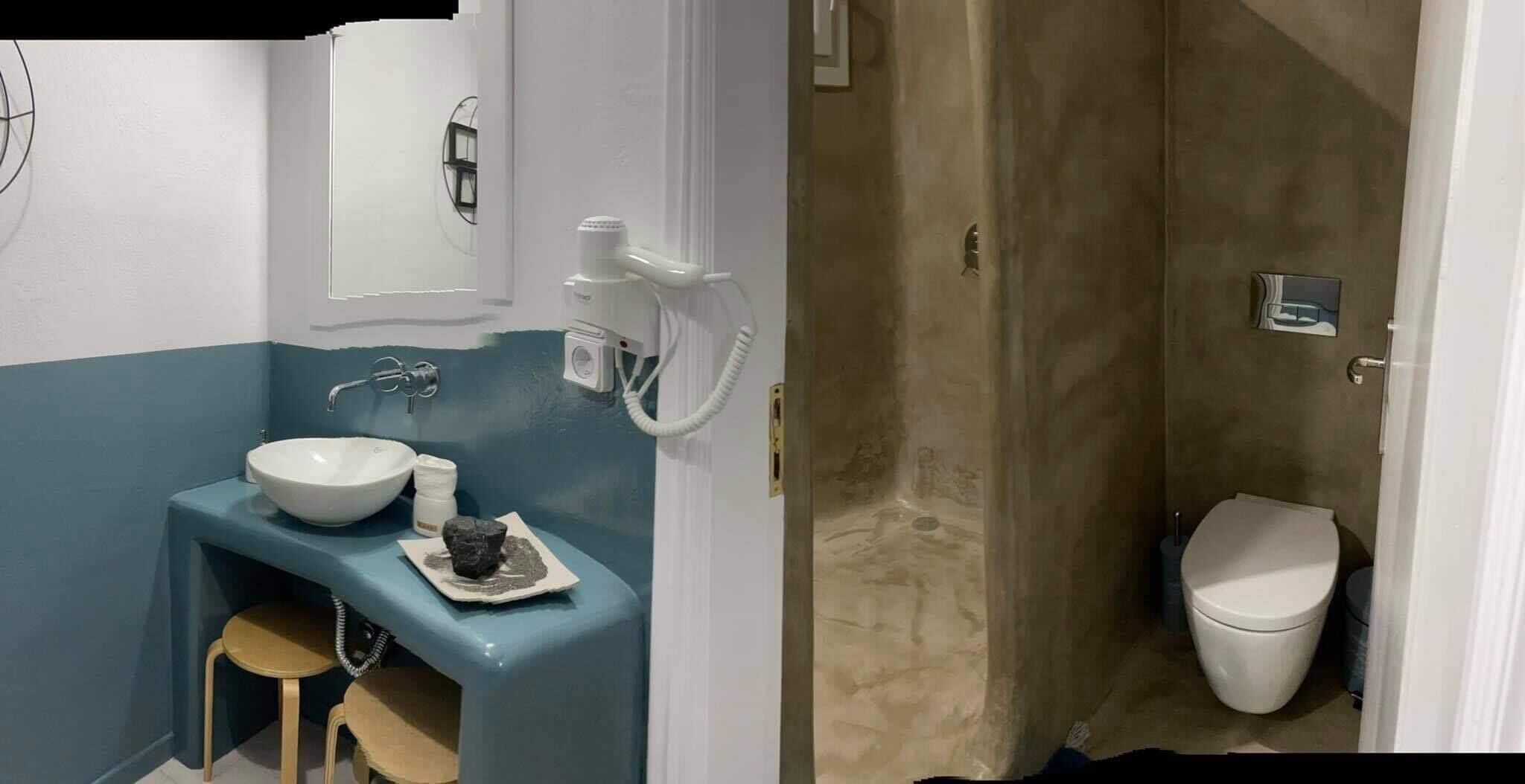 Un baño con lavamanos, espejo e inodoro.
