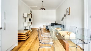A modern kitchen with a glass dining table, wooden chairs, and a chandelier. - Modern Royal Mile 2 bed Flat Edinburgh - Pass the Keys (Edinburgh)