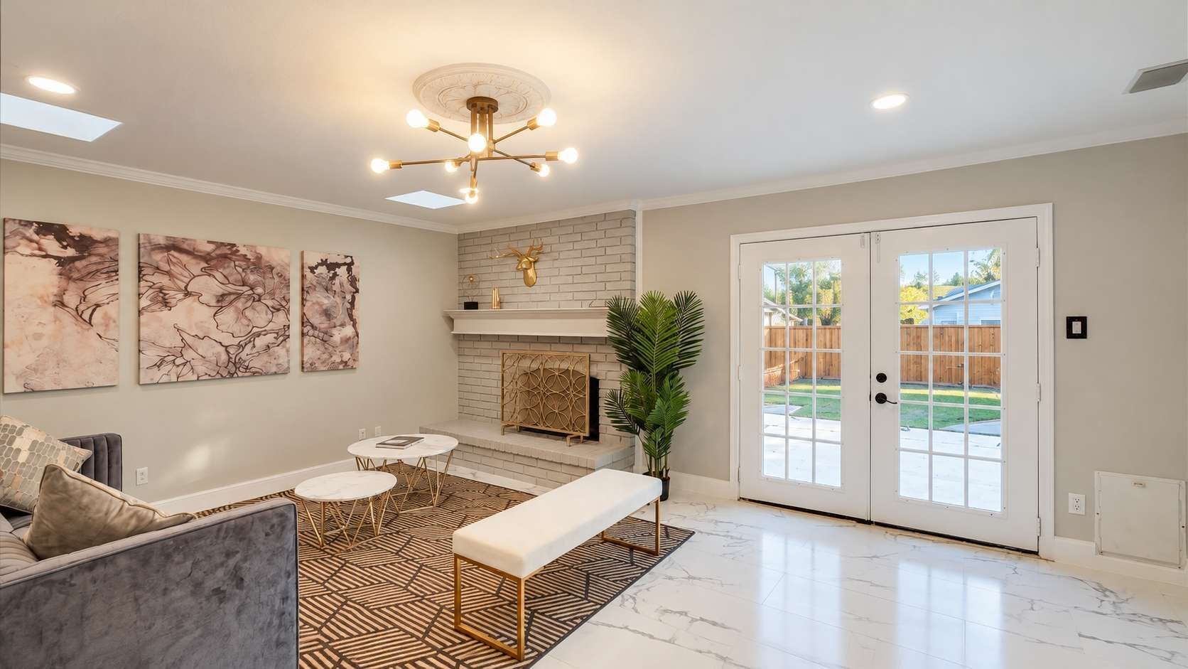 A spacious living room with a fireplace, a bench, and a dining area with round tables.