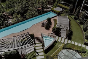 Un área de piscina en la azotea con múltiples tumbonas y una piscina central.