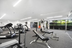 A gym with treadmills, weight machines, and benches.