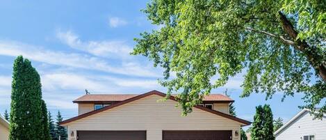 A two-story house with a garage and a well-maintained lawn.