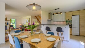 A modern kitchen with a central island, wooden cabinets, and stainless steel appliances. - Les Dryades - Villa familiale proche plage (Sarzeau)