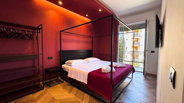 Ein modernes Schlafzimmer mit einem Himmelbett, einem Einbauschrank und Blick ins Freie.