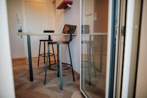A small dining area with a table, two chairs, and a glass partition.