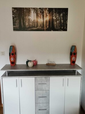 Eine Küche mit Arbeitsplatte, zwei Lautsprechern, einem kleinen dekorativen Gegenstand und einem Schrank darunter.