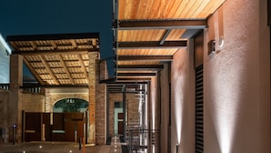 Ein modernes Gebäude mit einer Stein-Fassade, einer Holzdecke und mehreren Türen zum Innenbereich.