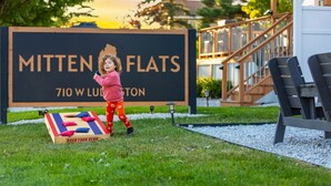 Lapsi leikkii lautapelin parissa kyltin edessä, jossa lukee »Mitten Flats», osoitteessa 710 W Lubbock.